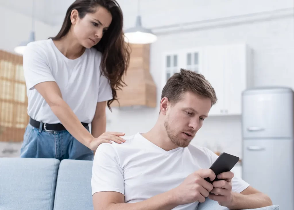 Couple with man texting on mobile phone